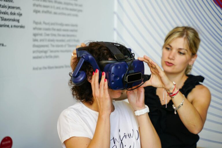 Two women exploring virtual reality indoors with a VR headset.