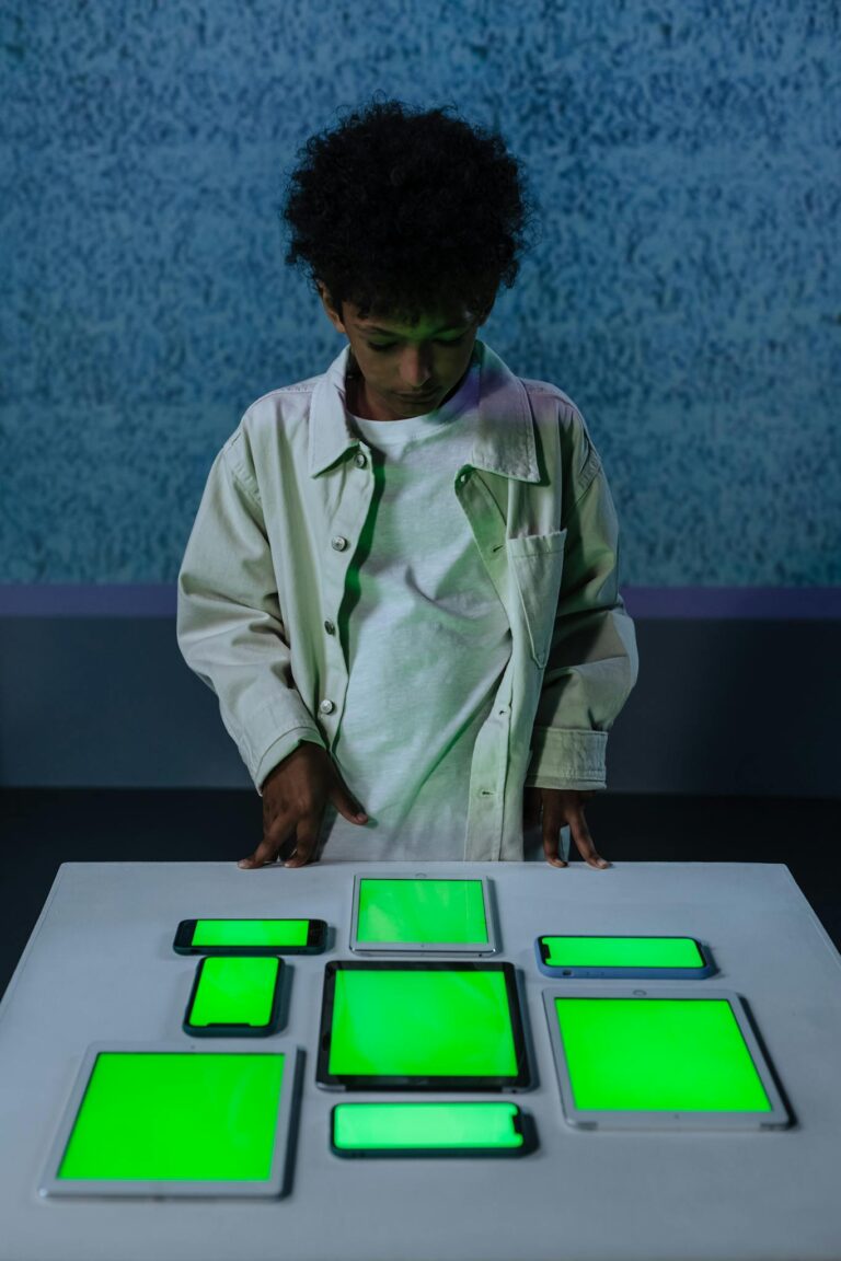 Young boy in studio with green screen gadgets on a table indoors.